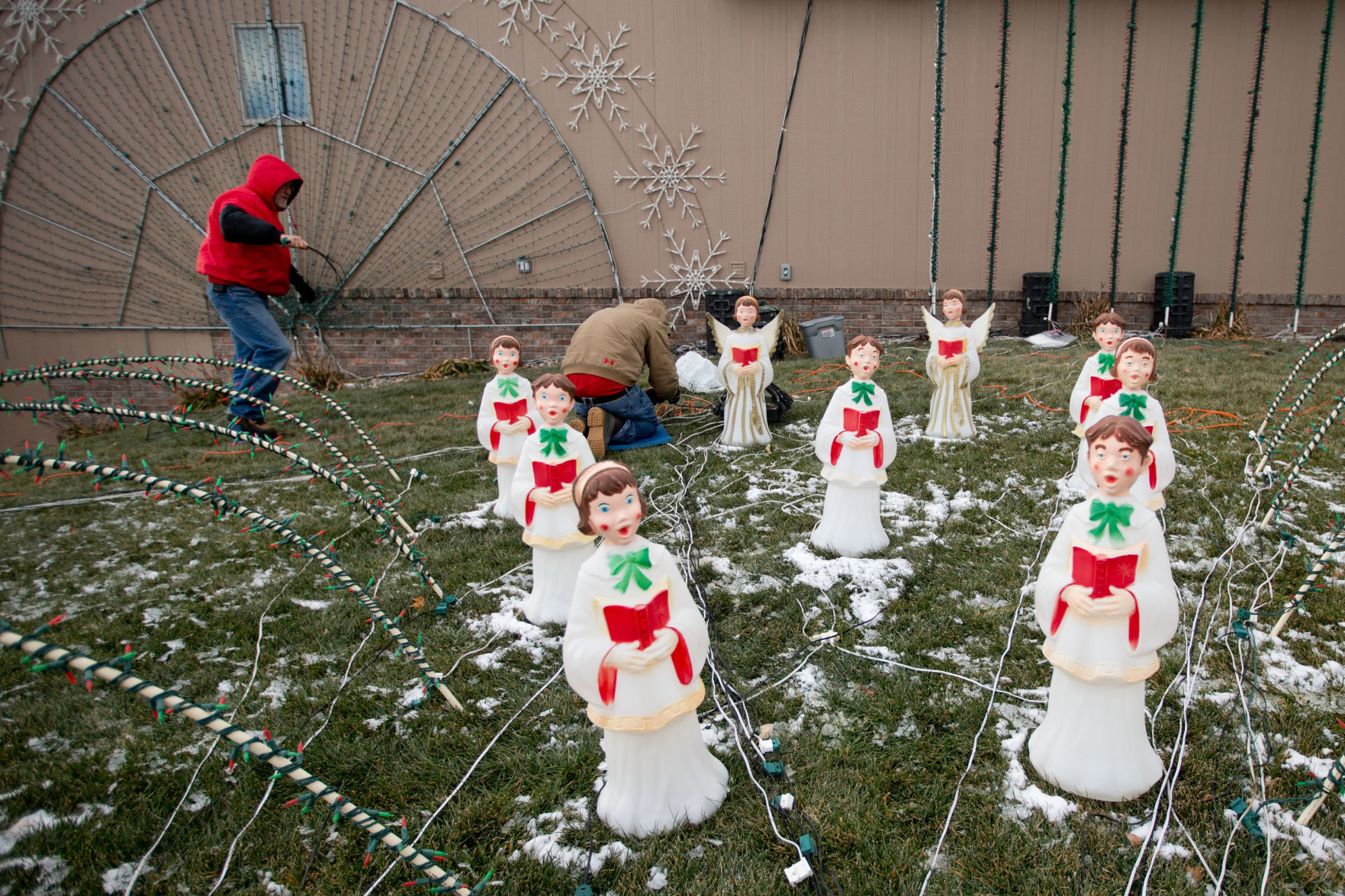 Marc Hansen, left, and his nephew Nick Scofield, center, set up Christmas lights in his yard in La Vista.